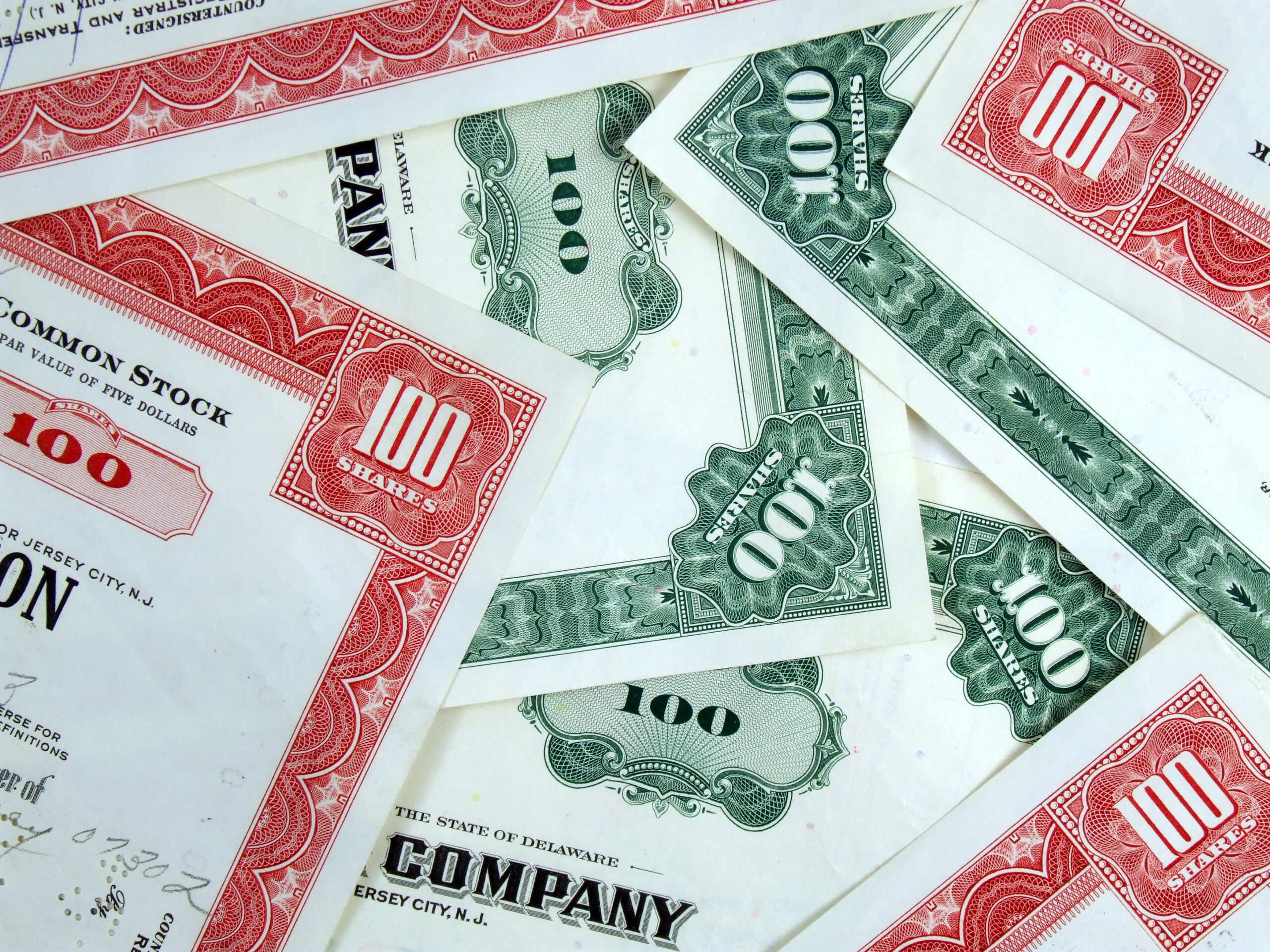 Red and green share certificates. Bull & bear - stock market. Old, vintage, retro shares. Common stock & bonds.