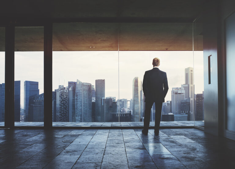 Businessman looking at city through window