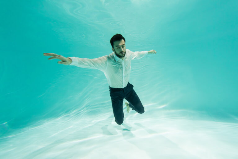 Muslim businessman in shirt diving in swimming pool