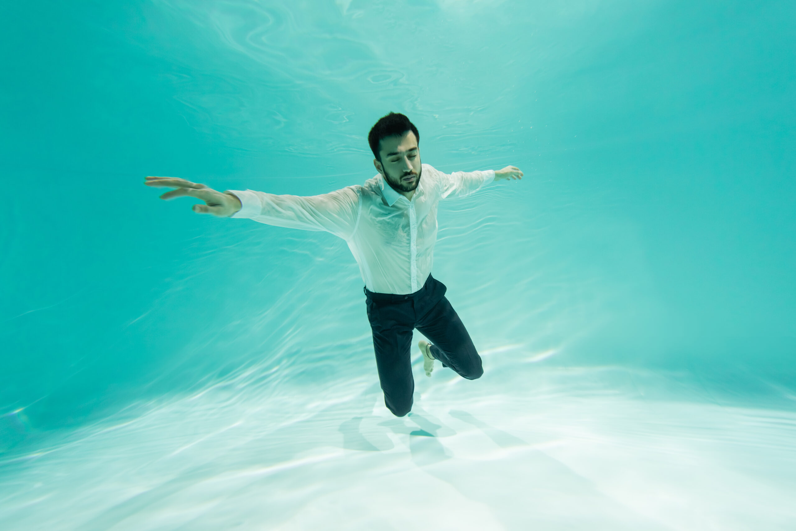 Muslim businessman in shirt diving in swimming pool