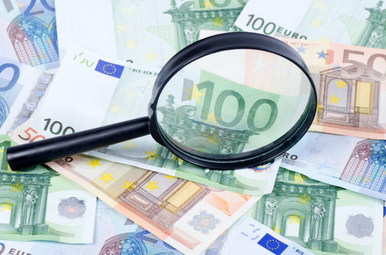 Magnifying glass lying on banknotes